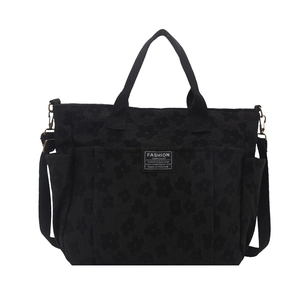 Large black shoulder bag with embossed floral pattern and adjustable strap for women