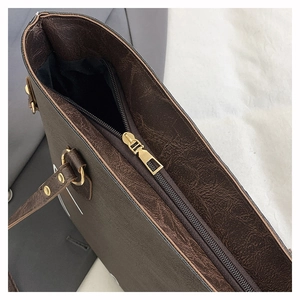 Detail der dunkelbraunen Vintage-Leder-Einkaufstasche mit goldenem Metallreißverschluss