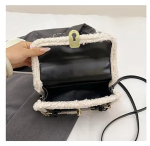 Macro detail of bicolored crossbody bag featuring plush trim and golden keyhole lock