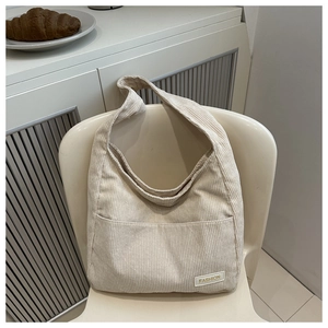 Détail du sac hobo en velours côtelé beige clair avec texture et bandoulière large