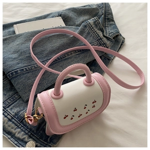 Close-up of pink and white cherry print handbag with golden twist lock detail