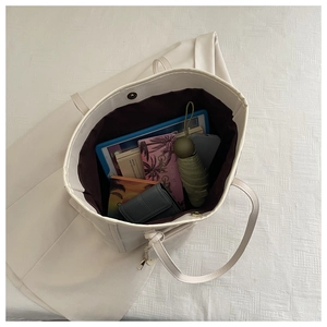 Large white faux leather tote bag interior showing brown lining and spacious storage capacity