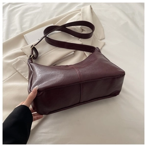 Detailed close-up of dark wine red PU leather shoulder bag with vertical stitching