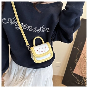 Detail of yellow cherry embroidery on PU leather handbag with detachable shoulder strap