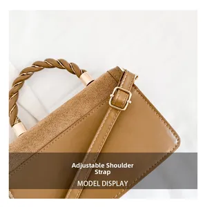 Detail of adjustable shoulder strap and braided handle on brown faux leather handbag