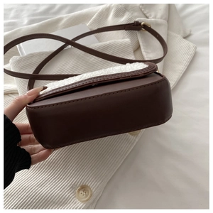 Detail of vintage saddle bag showing brown leather texture and soft white fleece edges