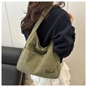 Détail du sac cabas en velours côtelé vert foncé avec bandoulière et étiquette