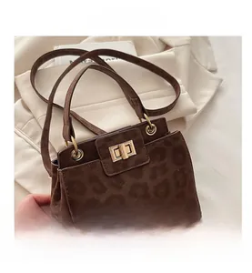 Close-up of leopard print handbag with gold twist lock and frosted texture finish