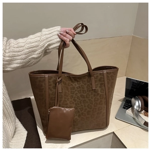 Detail of leopard print suede tote bag with matching zippered pouch and soft matte texture
