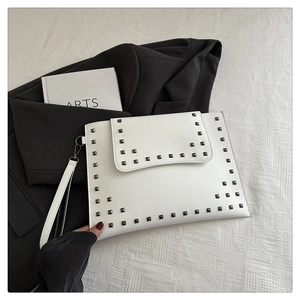 Detail of white faux leather envelope clutch with silver square studs and wrist strap