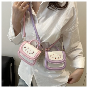Close-up of mini crossbody bag featuring cherry embroidery and colorful pastel leather