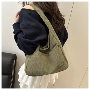 Détail du sac hobo en velours côtelé vert montrant la texture et l'étiquette