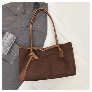 Detailed shot of dark brown suede tote bag with metal buckles and leather shoulder strap