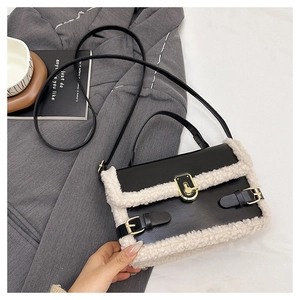 Detail of crossbody bag featuring black glossy leather and white faux fur trim with gold lock