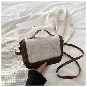 Detail of the vintage crossbody bag with brown leather and white faux fur flap and gold ring