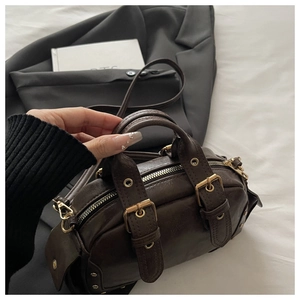 Close-up of dark brown vintage bowling bag with metal buckles and leather straps