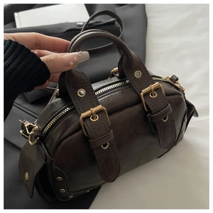 Close-up of vintage dark brown bowling bag with glossy texture and buckle details