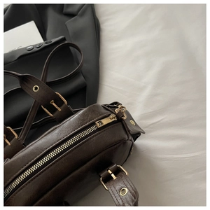Detail of vintage brown leather bag with high-quality gold hardware and smooth zippers