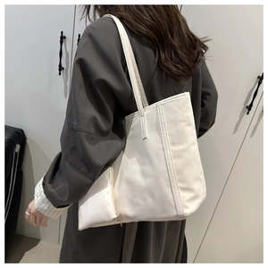 Dettaglio della borsa tote in ecopelle bianco crema con pochette abbinata e interno spazioso