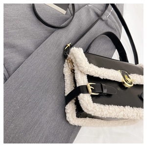 Detail of contrast stitch handbag with faux fur trim and gold twist lock closure