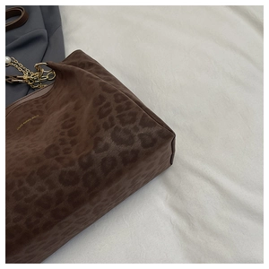 Detail of leopard print suede shoulder bag with gold chain and pearl accents