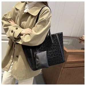 Detailed view of leopard print suede tote bag with small black zip pouch accessory