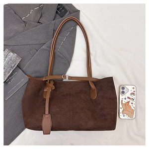 Close-up of vintage brown suede tote bag featuring adjustable leather shoulder straps