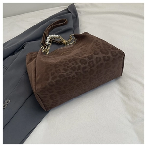 Close-up of leopard print tote bag with faux suede texture and elegant pearl chain strap