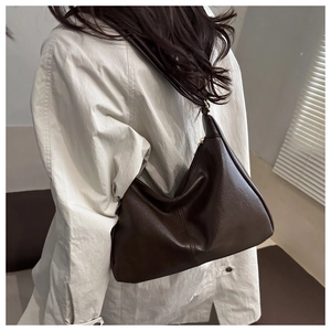 Macro shot of dark brown PU leather hobo bag with gold hardware and stitch details