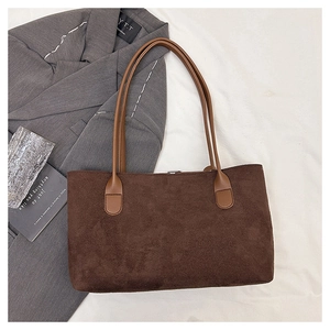 Detailed view of brown suede tote bag with leather straps and metal buckle closure