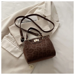 Detail of dark brown leopard print suede handbag with metal twist lock and shoulder strap