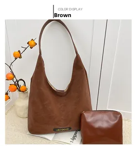 Detail view of the brown leather Hobo bag set featuring JACQEUE logo and inner pouch