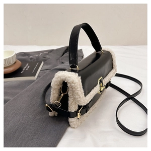 Detail of the high-contrast black leather and white faux shearling with gold metal lock