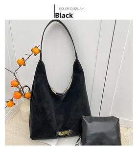 Detail view of the black tote bag set and small pouch on a stylish woven carpet