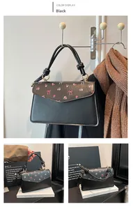 Close-up of black leather handbag with pink floral print and unique knotted handle detail