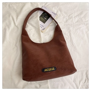 Detailed top view of brown leather Hobo bag with JACQUEUE label and textured surface