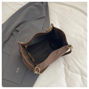 Close-up of leopard print tote bag interior with zipper pocket and gold metal rings
