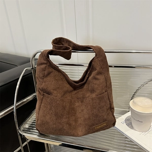 Sac cabas en velours côtelé marron avec grande poche et étiquette en cuir sur rack
