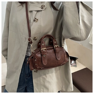 Detail of vintage brown bowling bag with gold studs and textured synthetic leather