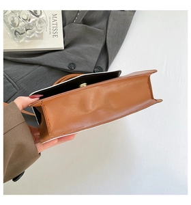 Detail shot of brown leather handbag featuring contrast white oil edge and neat stitching