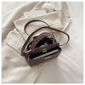 Detailed view of dark brown leopard embossed handbag interior with phone and lipstick