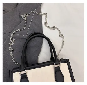Close-up of the monochrome checkered handbag with black leather trim and silver metal chain