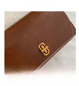 Close-up of vintage brown leather bag with retro wrinkled texture and bronze twist lock