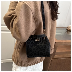 Close-up of leopard print bucket bag with gold twist lock on a winter wool coat