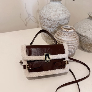 Brown faux leather crossbody bag with white shearling trim and golden twist lock