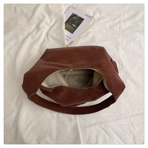 Top view of spacious brown faux leather tote bag with magnetic closure and inner lining