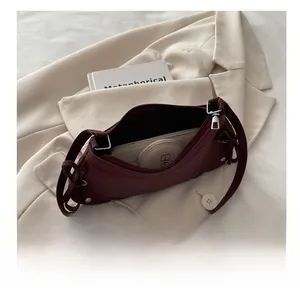 Interior view of burgundy shoulder bag showing large capacity for phone and cosmetics