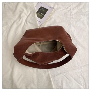 Detailed interior of a brown hobo shoulder bag showing large capacity and soft leather