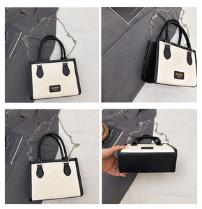 Detail view of monochrome plaid crossbody bag with gold fashion label and chain strap