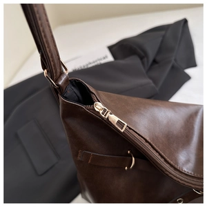 Détails du sac marron café avec fermeture éclair et finitions en métal doré poli